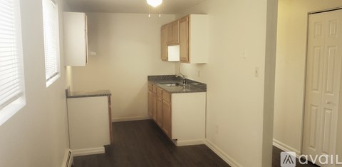 A kitchen with white appliances and wooden cabinets.