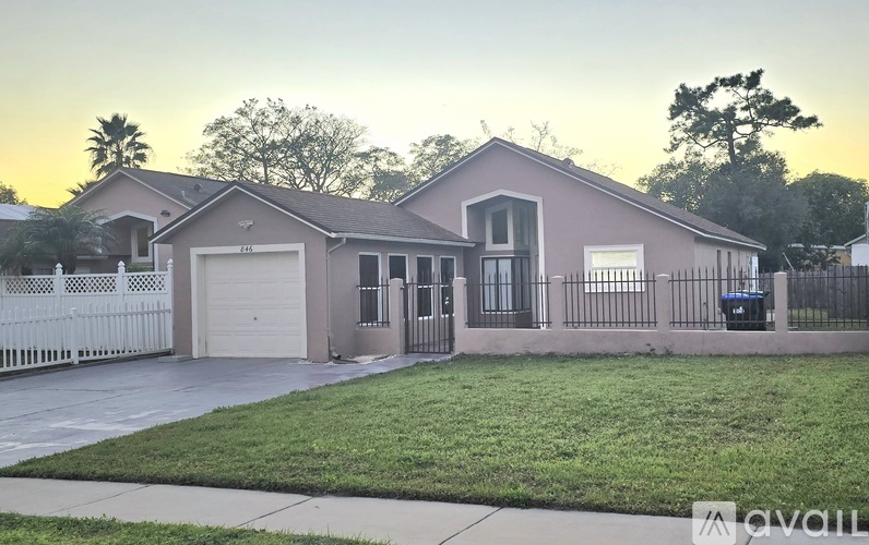 A house with a white fence and a garage door.