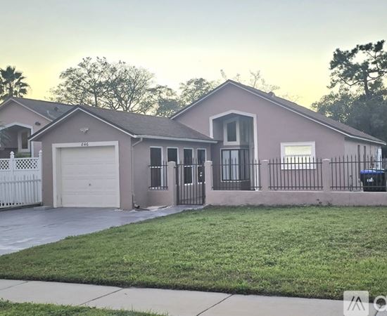 A house with a white fence and a garage door.