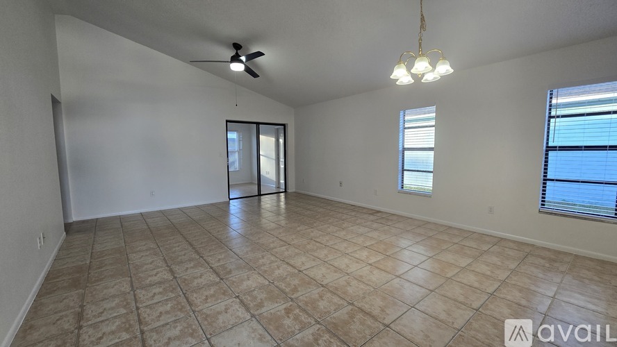 A spacious room with tiled flooring and a ceiling fan.