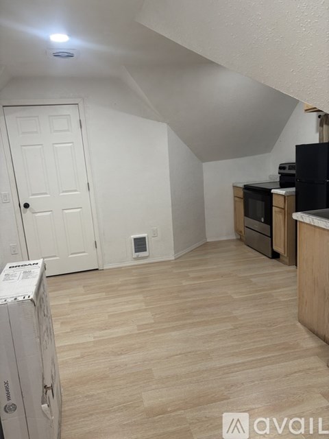 A room with a white door and a wooden floor.