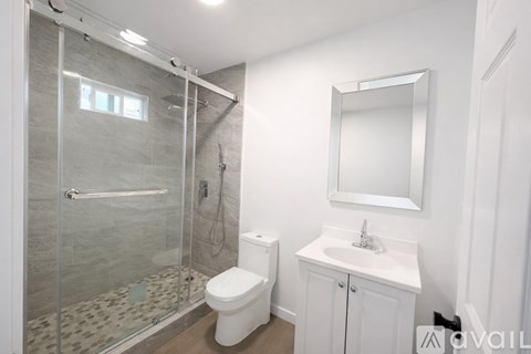 A bathroom with a toilet, sink, and shower.
