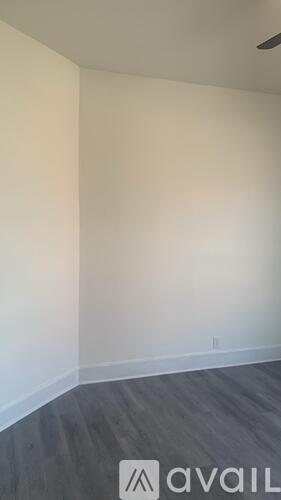 A room with a wooden floor and a white wall.