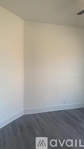 A room with a wooden floor and a white wall.