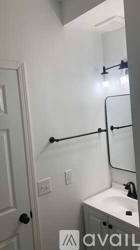 A bathroom with a white sink and a mirror.