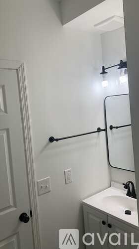 A bathroom with a white sink and a mirror.