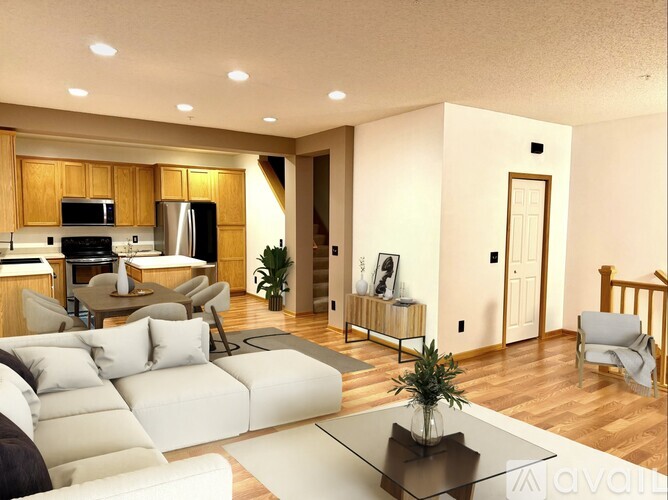 A spacious room with wooden floors and a large window with curtains.