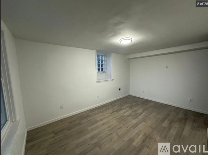 A room with wooden flooring and a window with blinds.