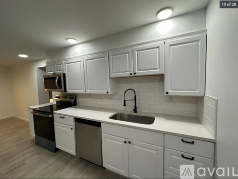 A kitchen with white cabinets and a sink.