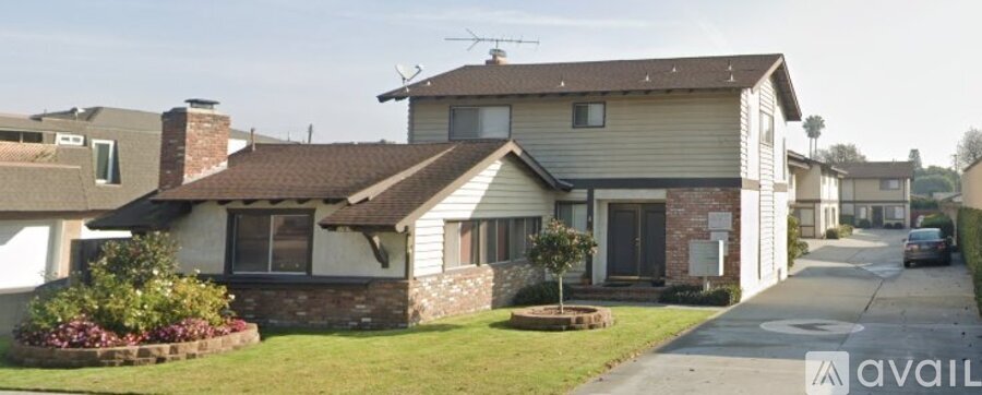 A house with a tree in bloom in front of it.