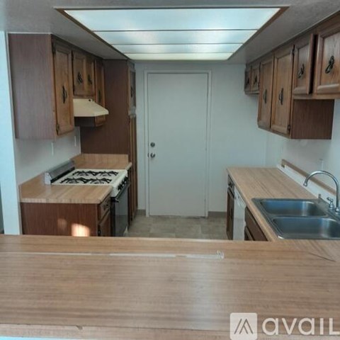 A kitchen with wooden cabinets and a white door.