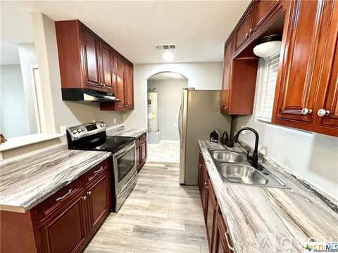 A kitchen with wooden cabinets and a granite countertop.