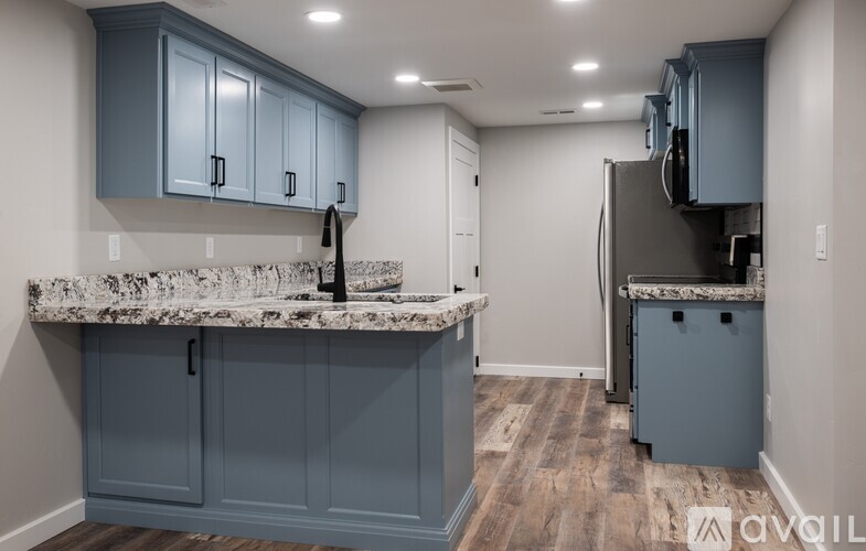 A kitchen with a marble countertop and blue cabinets.