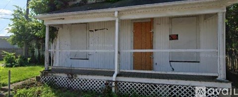 A small white house with a wooden door and a porch.