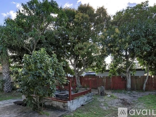 A backyard with a fire pit and trees.