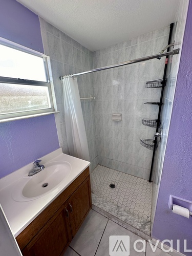 A bathroom with purple walls and a white sink.