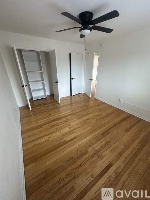 A room with a ceiling fan and wooden flooring.