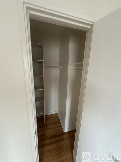A white pantry with shelves and a doorway.