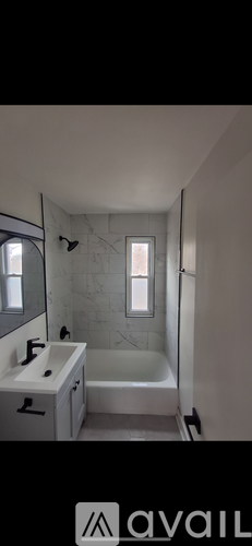 A bathroom with a white tub, sink, and mirror.
