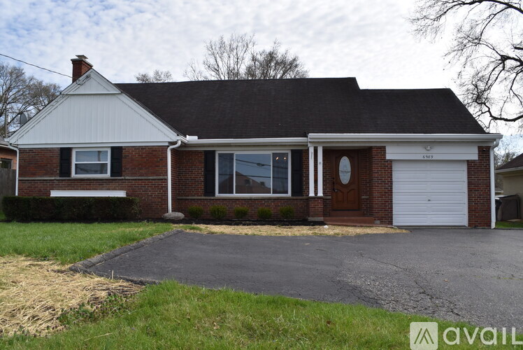 A house with a white garage door and a brick exterior.