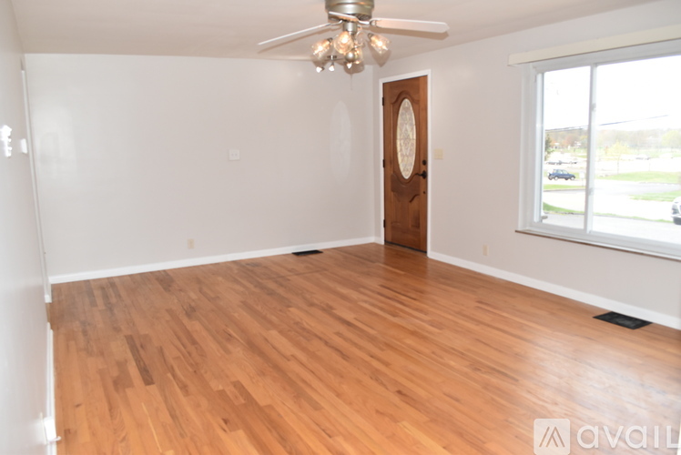 A room with wooden flooring and a ceiling fan.