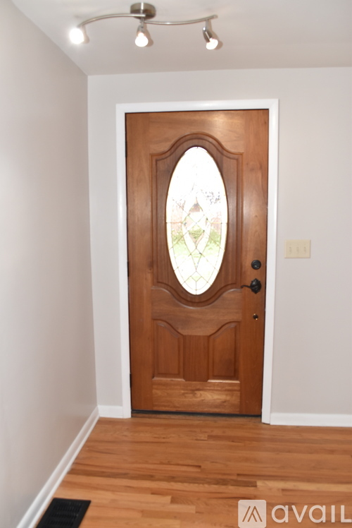 A wooden door with a glass window in the middle.