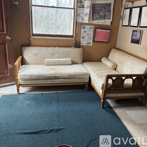 A room with two couches and a window.