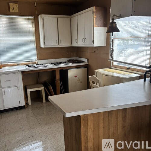 A kitchen with white cabinets and a wooden counter.