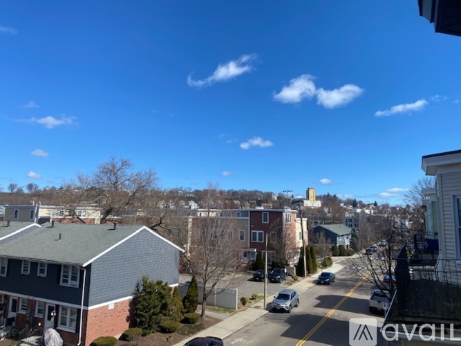 A sunny day in a quiet neighborhood with houses and cars.