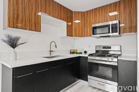 A kitchen with black cabinets and a white countertop.