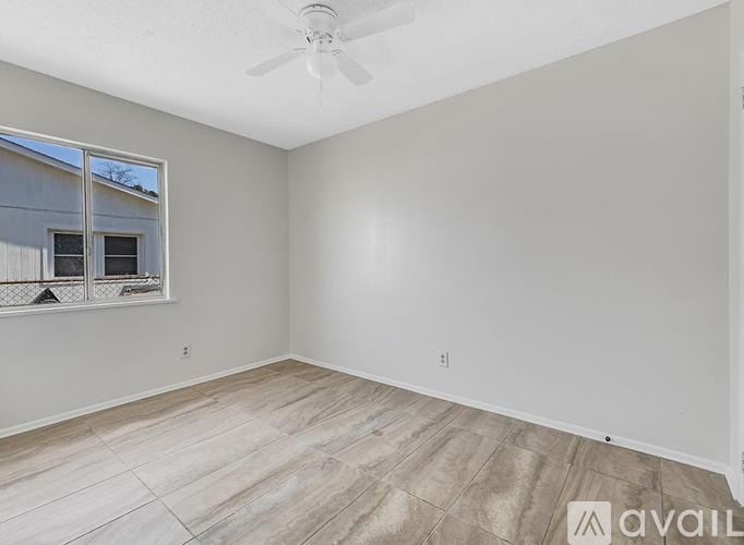 A room with a tiled floor and a window with a view of a building outside.