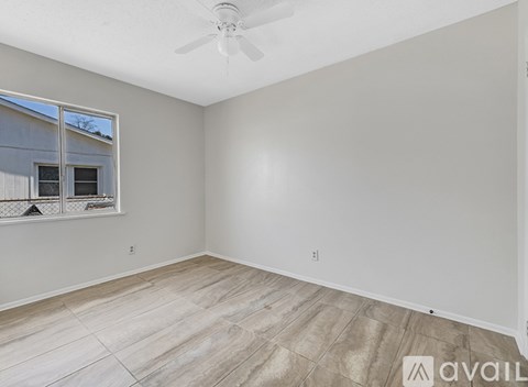 A room with a tiled floor and a window with a view of a building outside.
