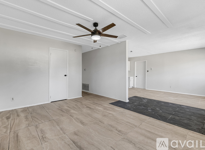 A kitchen with white cabinets and a black mat on the floor.