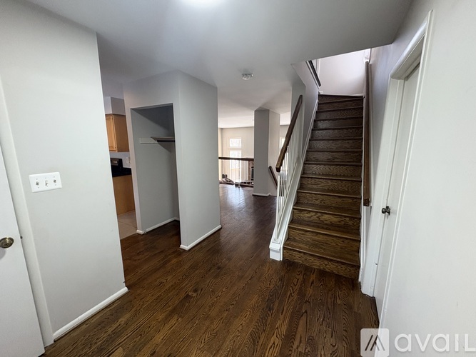 A spacious hallway with wooden floors and a staircase.