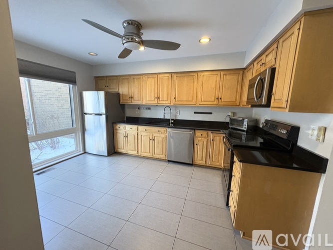 A kitchen with wooden cabinets and a black countertop.