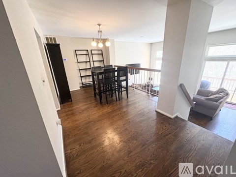 A living room with a black sofa and a wooden floor.