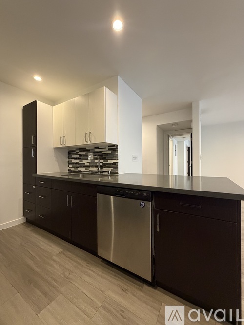 A modern kitchen with dark brown cabinets and stainless steel appliances.