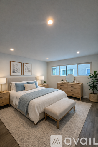 A bedroom with a bed, nightstand, and a plant.