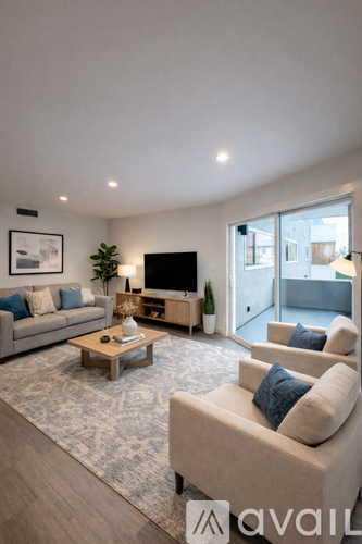 A living room with a grey couch, a wooden coffee table, and a flat screen TV.