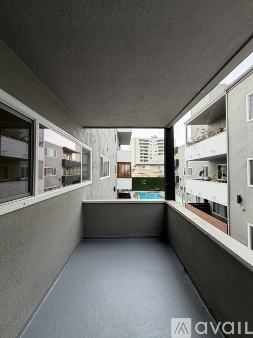 A balcony with a pool in the distance.