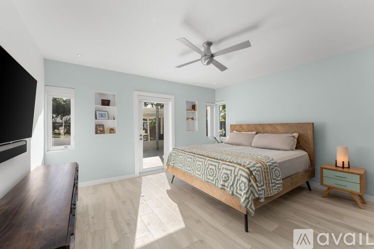 A bedroom with a large bed and a ceiling fan.