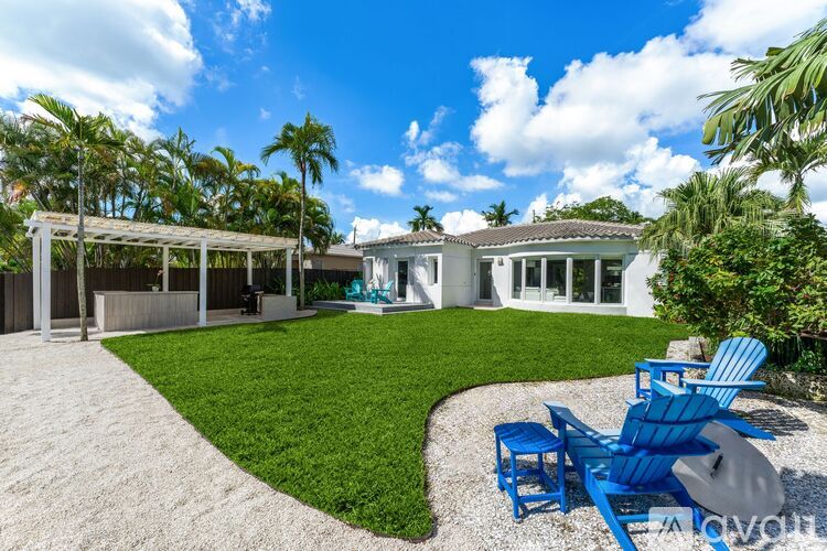 A house with a white exterior and a blue lawn chair in front of it.