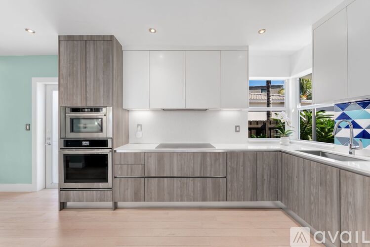 A modern kitchen with wooden cabinets and a stainless steel oven.