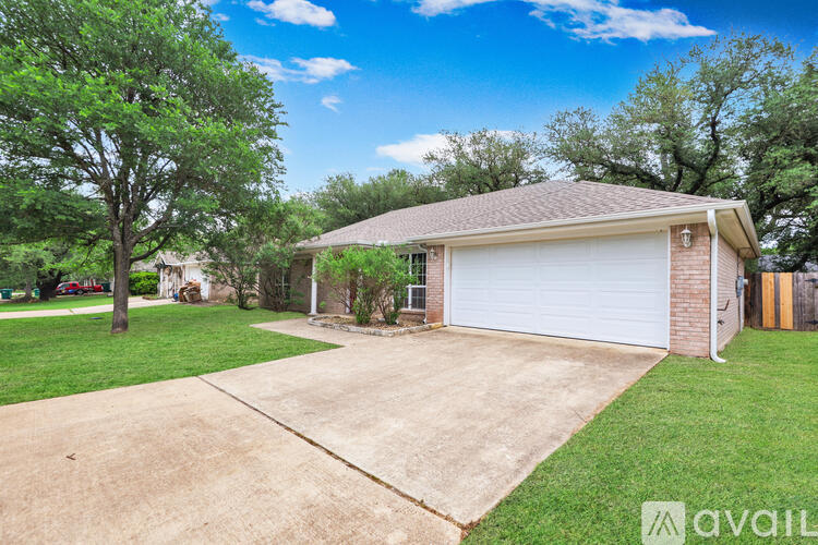 A house with a garage and a driveway in front of it.