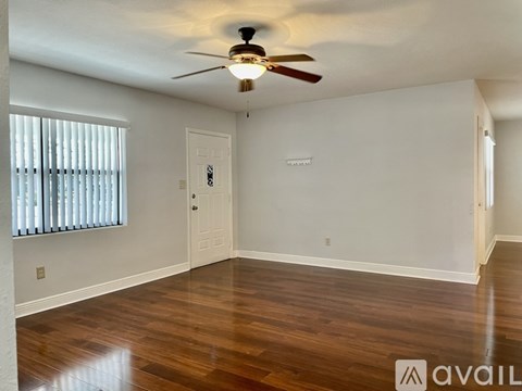 A room with wooden floors and a ceiling fan.
