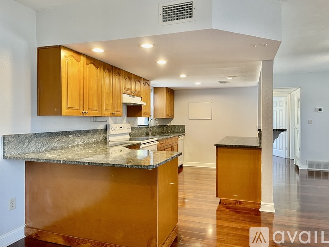 A kitchen with wooden cabinets and a granite countertop.