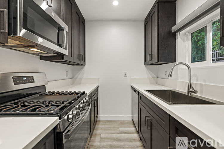 A modern kitchen with a stove top oven and a microwave above it.