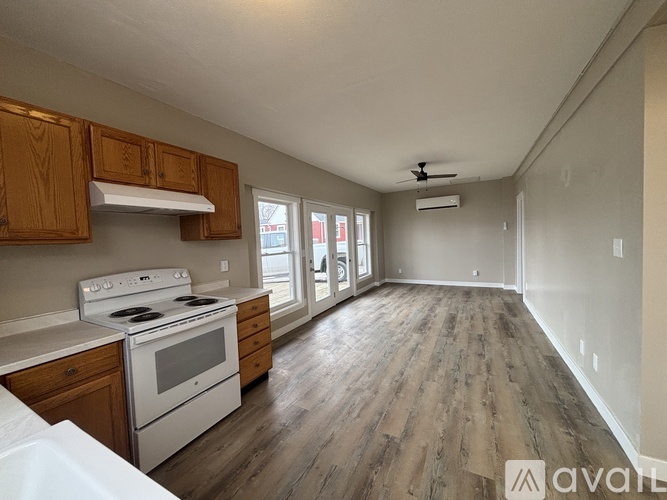A kitchen with wooden cabinets and a white stove top oven.
