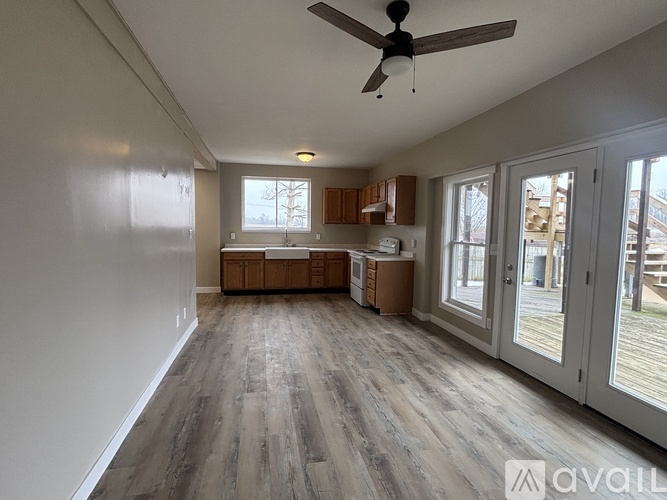 A spacious room with a ceiling fan and wooden flooring.