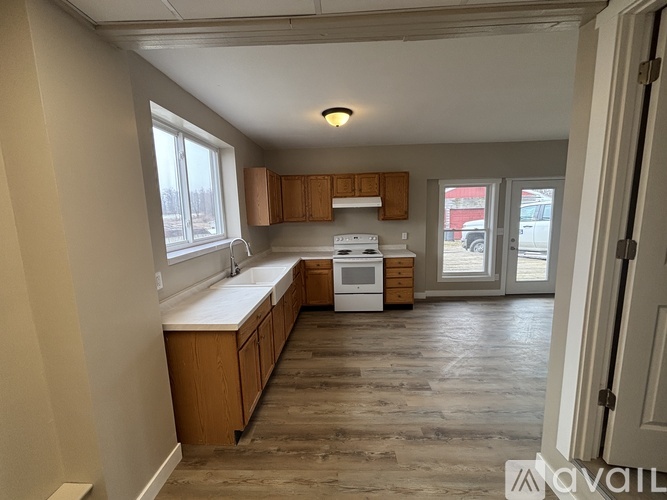 A kitchen with wooden cabinets and a white stove top oven.